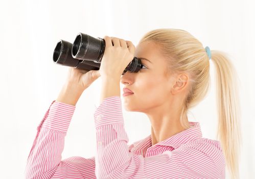 Young blonde woman looking through binoculars.