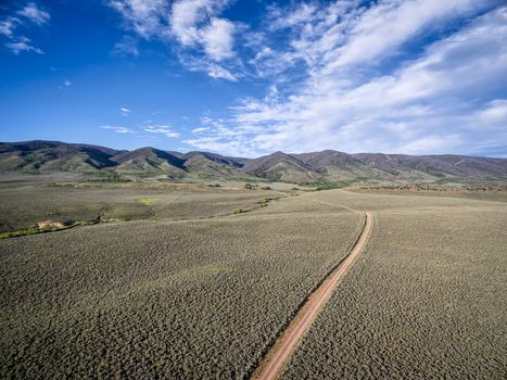 ranch road and Medicine Bow Mountains in North Park near Walden, Colorado - aerial view