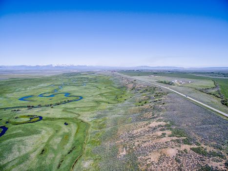 Illinois River meanders through Arapaho National Wildlife Refuge, North Park near Walden, Colorado, early summer aerial view