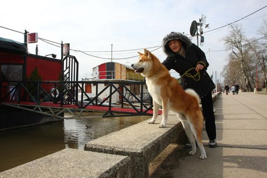 Lady with Akita Inu enjoying on the riverside