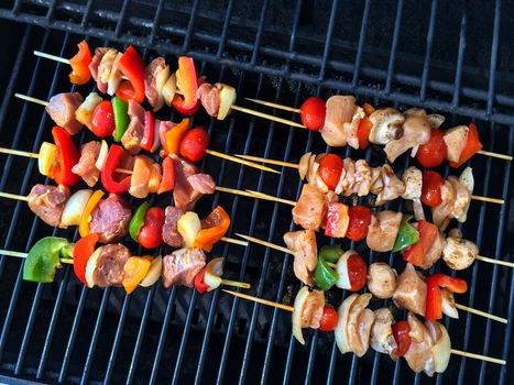 Meat and vegetable skewers on a grill. Outdoor barbecue.