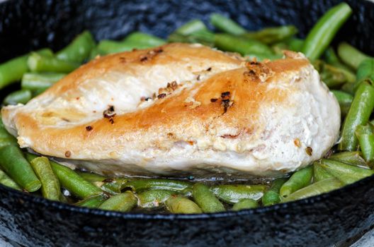 Grilled chicken breast and green beans in the pan, rosy crispy crust.