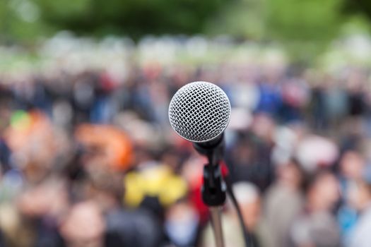 Microphone in focus against blurred crowd. Demonstration.