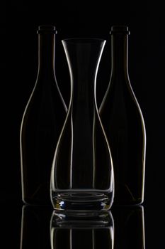 Empty glass and bottles on the black background