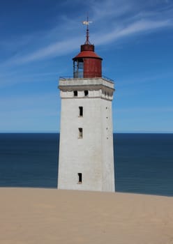 Old Lighthouse with Sand Dune and Blue Ocean in Horizon