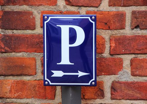 Enamel Parking Lot Sign with Arrow on Red Brick Tile Background