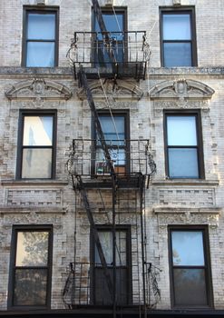 Fire Escape Steel Ladder on White Apartment Building Facade in New York