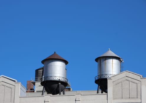 Steel Water Tanks on Building Roof with Blue Sky Background