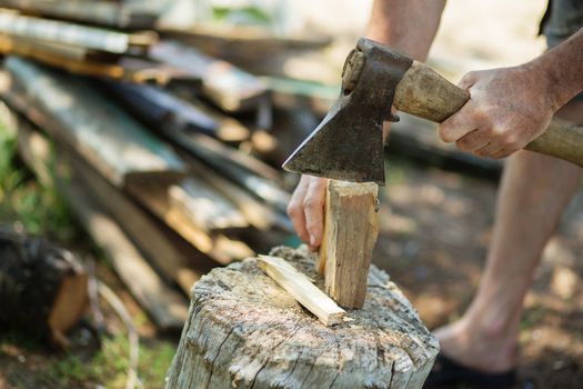 Man with an ax chops firewood. Man is chopping wood with vintage axe