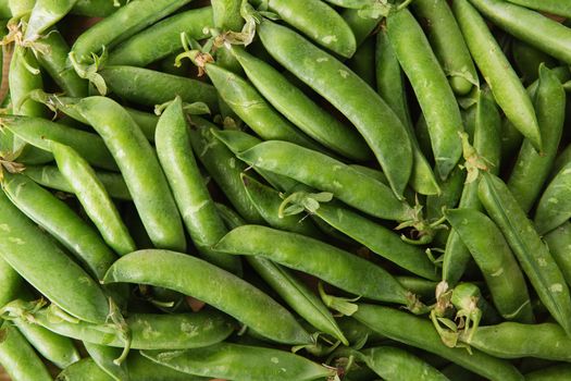 green peas in pods freshly picked on wood. Some green peas. Fresh green peas. green pods with peas as background.