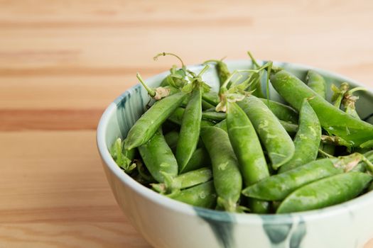 green peas in pods freshly picked on wood. Some green peas. Fresh green peas. green pods with peas as background. Green peas into a bowl