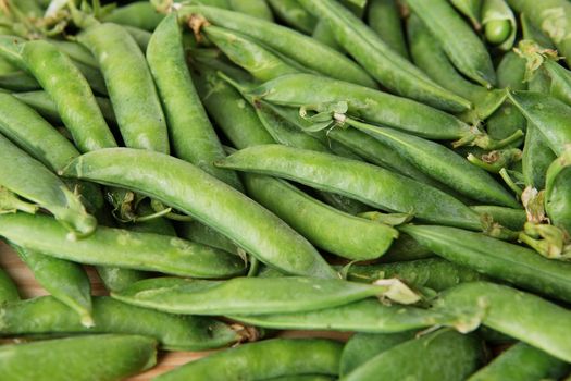green peas in pods freshly picked on wood. Some green peas. Fresh green peas. green pods with peas as background.