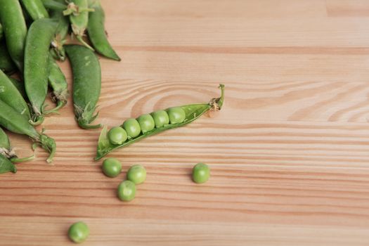 green peas in pods freshly picked on wood. Some green peas. Fresh green peas. green pods with peas as background.
