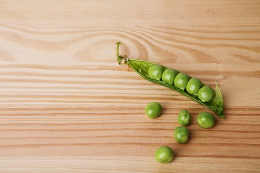 green peas in pods freshly picked on wood. Some green peas. Fresh green peas. green pods with peas as background. Green peas into a bowl
