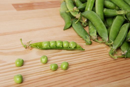 green peas in pods freshly picked on wood. Some green peas. Fresh green peas. green pods with peas as background.