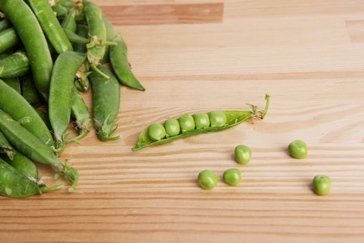 green peas in pods freshly picked on wood. Some green peas. Fresh green peas. green pods with peas as background.