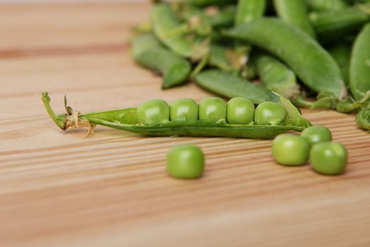 green peas in pods freshly picked on wood. Some green peas. Fresh green peas. green pods with peas as background. Green peas into a bowl. green peas in pods freshly picked on wooden background texture