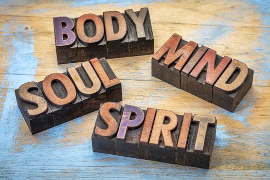 body, mind, soul and spirit word abstract -text in vintage grunge wood letterpress printing blocks against grunge wood