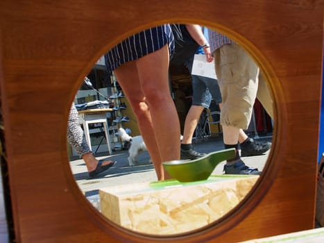 Legs of people reflected in an lld style mirror in a street flea market    