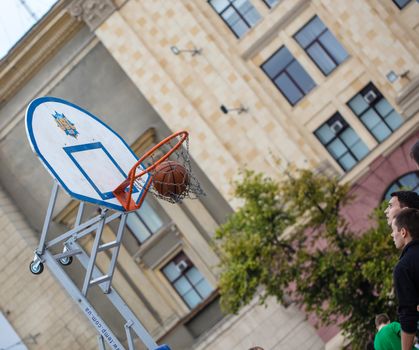 KHARKOV, UKRAINE - JUNE 11, 2016: Man throws ball into the ring, streetball competitions on Freedom Square in Kharkov