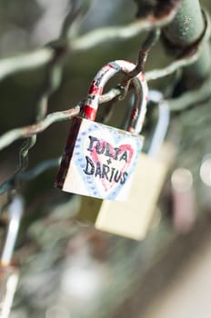 Close-up on lockers symbolizing everlasting love on a bridge fence