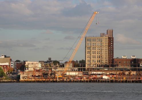 Industrial Crane at Building Site in New York with Blue River in Foreground