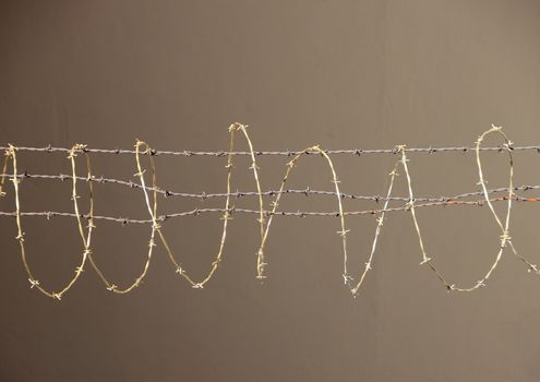 Isolated Barbwire Fence in Silver and Gold Metal on Brown Background