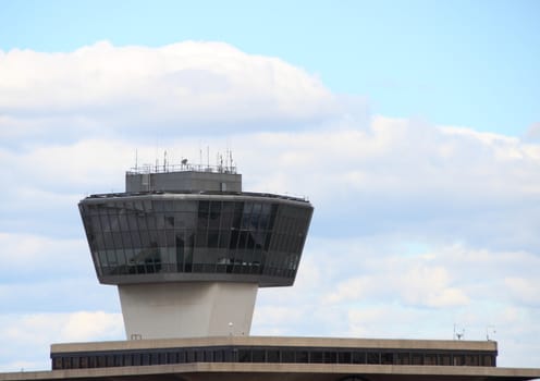 Airport Control Tower with Black Windows and Blue Sky Background