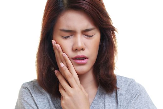 Teen woman pressing her bruised cheek with a painful expression as if she's having a terrible tooth ache.