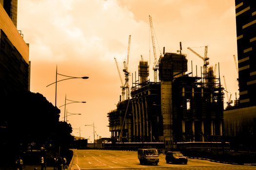 Silhouette of construction workers on scaffold working under a hot sun