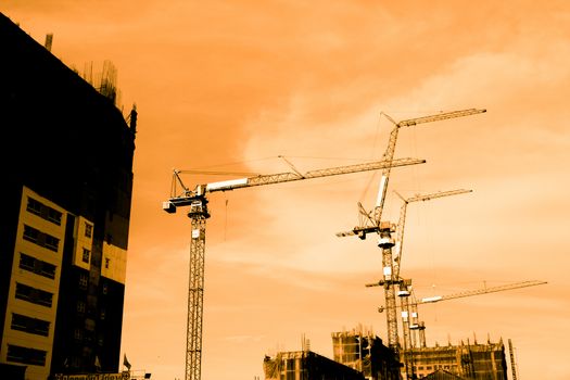 Silhouette of construction workers on scaffold working under a hot sun