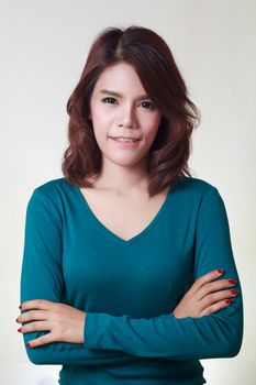 Young woman crossed arms standing against white. Confident pose