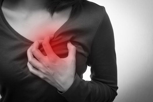 Woman is clutching her chest, acute pain possible heart attack