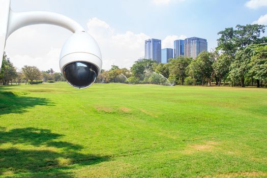 security camera in City park under blue sky with building background