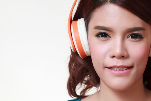 Beautiful young woman with headphones listening to the music