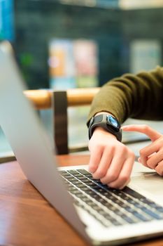 Woman use of wearable watch and laptop computer