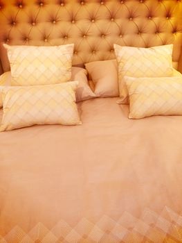 Luxurious bed with silky linen and lots of pillows.