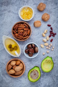Selection food sources of omega 3 and unsaturated fats. super food high omega 3 and unsaturated fats for healthy food. Almond ,pecan ,hazelnuts,walnuts ,olive oil ,fish oil and avocado on stone background .