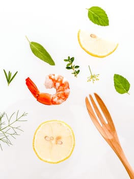 Fresh steamed shrimp isolate on white background. Boiled prawns with ingredients. Boiled prawns with herbs Fennel ,parsley,rosemary,lemon and mint with fork isolate on white background.