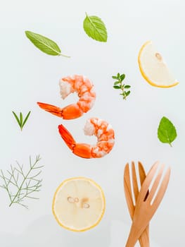 Fresh steamed shrimp isolate on white background. Boiled prawns with ingredients. Boiled prawns with herbs Fennel ,parsley,rosemary,lemon and mint with fork isolate on white background.