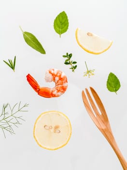 Fresh steamed shrimp isolate on white background. Boiled prawns with ingredients. Boiled prawns with herbs Fennel ,parsley,rosemary,lemon and mint with fork isolate on white background.