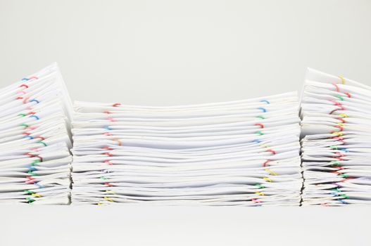 Pile overload document of report and receipt with colorful paperclip place on white background.