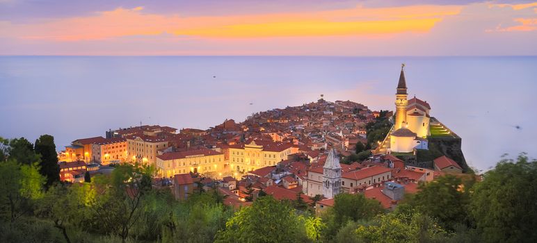 Romantic colorful sunset over picturesque old town Piran, Slovenia. Senic panoramic view. Panoramic composition.