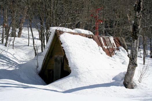 Snow-covered shed in the mountains of Dombai, Caucasus