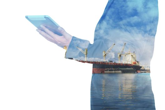 Double exposure of businessman hand hold tablet, cargo port ship at sea port concept