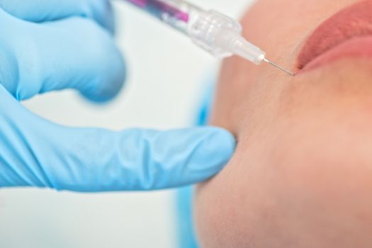 Closeup of woman gets injection in her lips