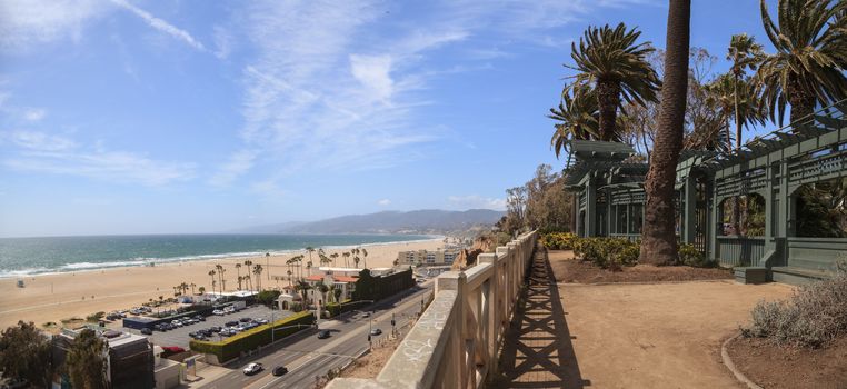 Along the Santa Monica coastline with a blue sky over the white sand of the beach in Southern California, United States.