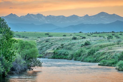 St Vrain Creek and Front Range of Rocky Mountains at dusk, St Vrain State Park near Longmont, Colorado