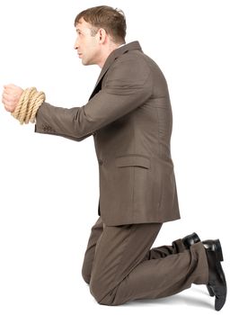 Young man kneeling with bound hands isolated on white background