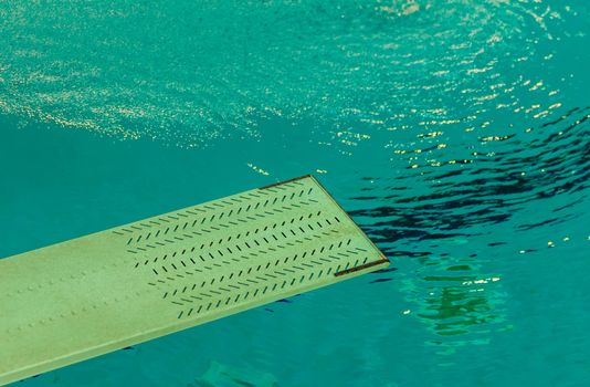 the first floor of a trampoline in the background water of a swimming pool